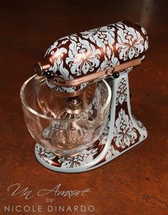 a glass bowl with a lid on top of a wooden table next to a metal stand