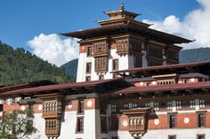 an old building with many windows in front of mountains