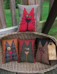 four decorative pillows are sitting on a wicker basket