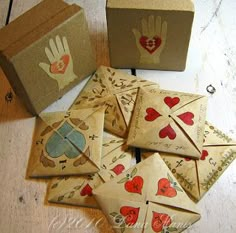 several envelopes with hearts and hand prints on them, sitting next to a box