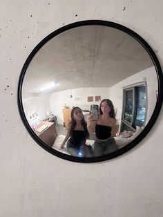 two women are taking a selfie in the mirror