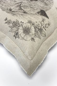 The Hideaway Cushion laying on white background with a detail image of the corner detail and the tattoo inspired rosehip branches are shown.