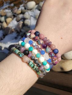 Each bracelet measures about 7 inches and is made with elastic string. 1. Rhodochrosite, Lepidolite, Sodalite 2. Sea Sediment Jasper and Amethyst 3. Rose Quartz and Glass 4. White Horseshoe Shell and Aqua Quartzite 5. Larvikite, Lepidolite, Obsidian 6. African Turquoise, Sunstone Jasper And Amethyst, Birthstone Charm Necklace, African Turquoise, Jasper Pendant, Cute Bracelets, Birthstone Charms, Stunning Earrings, Star Fashion, Stretch Bracelets