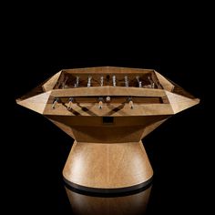 a wooden table with many different items on it's top and bottom section, in front of a black background