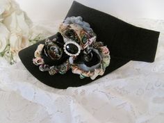 I designed this adorable black visor with beautiful matching variegated shabby flowers. I added a beautiful black and rhinestone center accent. Visor has velcro back I also have more colors that I will be listing as well. See more hats and visor here: https://www.etsy.com/shop/theraggedyrose?ref=seller-platform-mcnav&section_id=10557807 Custom orders alway welcome. Thanks for visiting my shop. Adjustable Black Top Hat With Curved Brim, Adjustable Black Costume Hat, Adjustable Black Brimmed Costume Hat, Adjustable Black Brimmed Costume Hats And Headpieces, Black Brimmed Hat Band One Size Fits Most, Black Brimmed Hat Band, Black Adjustable Mini Baseball Caps, Black Visor With Curved Brim, One Size Fits Most, Vintage Black Visor Hat