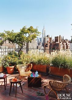 an outdoor patio with chairs, tables and potted plants on the top of a building