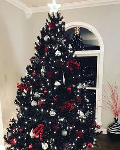 a black christmas tree with red and silver ornaments