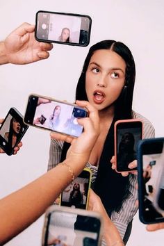 a group of people holding up cell phones in front of one another with their mouths open