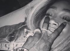 a black and white photo of a woman holding her hand up to her face while wearing a watch