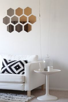 a living room with white furniture and mirrors on the wall