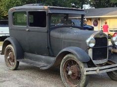 an old car parked in front of a house