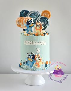 a blue cake with cartoon characters on it