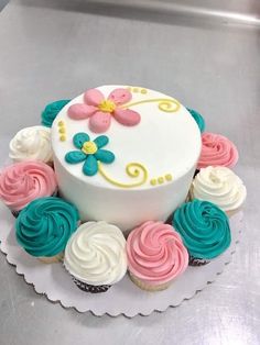 a white cake with pink, blue and yellow frosting