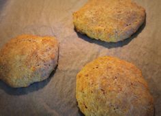 three biscuits sitting on top of a piece of waxed paper next to each other