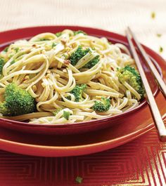 a red plate topped with pasta and broccoli