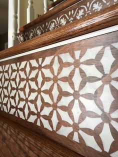 an intricately carved wood panel on the side of a staircase rail with handrails