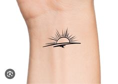 a small sun tattoo on the wrist that is black and white with a line drawing