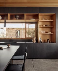 a kitchen with black cabinets and wooden shelves