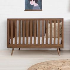 a baby crib with a painting on the wall