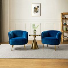 two blue chairs sitting next to each other on top of a hard wood flooring