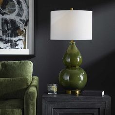 a green lamp sitting on top of a table next to a chair