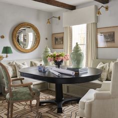 a living room filled with furniture next to a mirror and table in front of a window