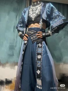 a mannequin dressed in blue and black clothing with an elaborate headdress