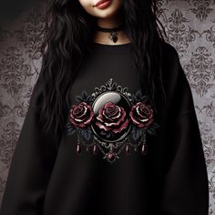 Cozy sweatshirt with a floral graphic, inspired by the vintage charm of a gothic Victorian cameo. Comfy classic fit and crew neckline for a comfortable and casual look. Looks great with leggings, black jeans, leather pants, or pair it with a skirt or a dress.  Perfect for both lounging with a book and going out on a colder day.                                                           Great gift idea for rose lovers, alternative fashion fans, romantic Valentine's gifts, or anyone who appreciates soft gothic and dark aesthetics.   ● Fits true to size. ● For best fit - measure one of your sweatshirts at home and compare it with the product size chart (see photos).  ● Made from a soft and durable fabric blend of 50% cotton and 50% polyester. ● Tear-away label. ● Eco-friendly, ethically grown Emo Style Sweatshirt For Fall Alternative Fashion, Black Gothic Sweatshirt With Graphic Print, Gothic Halloween Graphic Sweatshirt, Gothic Long Sleeve Sweatshirt With Graphic Print, Alternative Style Crew Neck Sweatshirt For Alternative Fashion, Victorian Cameo, Dark Aesthetics, Floral Sweatshirt, Gothic Rose