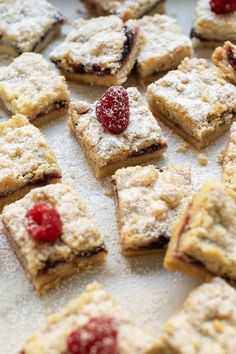 small desserts with raspberries and powdered sugar are on a baking sheet