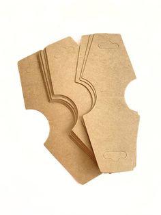 three pieces of brown cardboard sitting next to each other on a white surface with one piece cut out