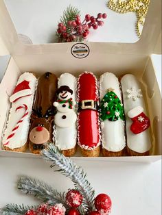 a box filled with lots of different types of decorated cookies next to a christmas tree