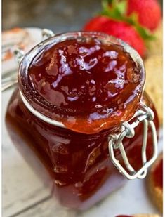 a jar of strawberry jam sitting on top of a table