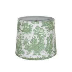 a green and white lampshade with trees on the bottom, in front of a white background