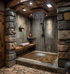 a rustic bathroom with stone walls and flooring is shown in this image, the shower has