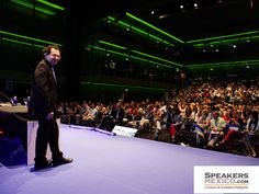 a man standing at a podium in front of an audience