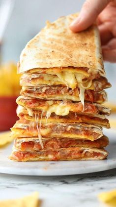 a stack of quesadilla stacked on top of each other with melted cheese