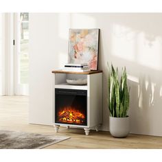 an electric fireplace in a living room with a potted plant on the side table