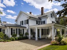 a large white house with black shutters on the front