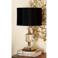 a lamp sitting on top of a table next to a book and a wall decoration