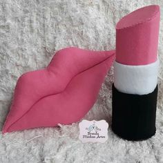 a pink and black hat sitting on top of a white carpet next to a roll of toilet paper