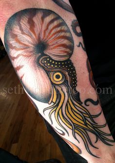 a man's arm with an octopus tattoo on it