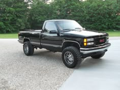 a black pick up truck parked in a driveway