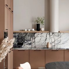 a kitchen with marble counter tops and cabinets in the corner, along with a plant