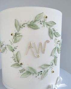 a white cake with green leaves and the word awn on it's side