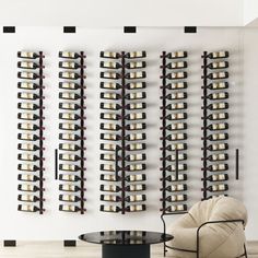 a room with a chair, table and wine rack on the wall