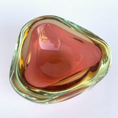 a glass bowl sitting on top of a white table next to a red and yellow object