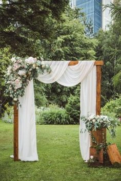 an outdoor ceremony setup with white drapes and flowers