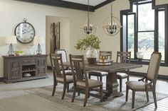 a dining room table and chairs with a clock on the wall in the back ground