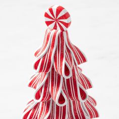 a red and white christmas tree made out of candy canes on top of snow