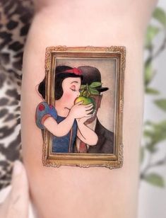 a woman's arm with a painting on it and a frame holding a plant